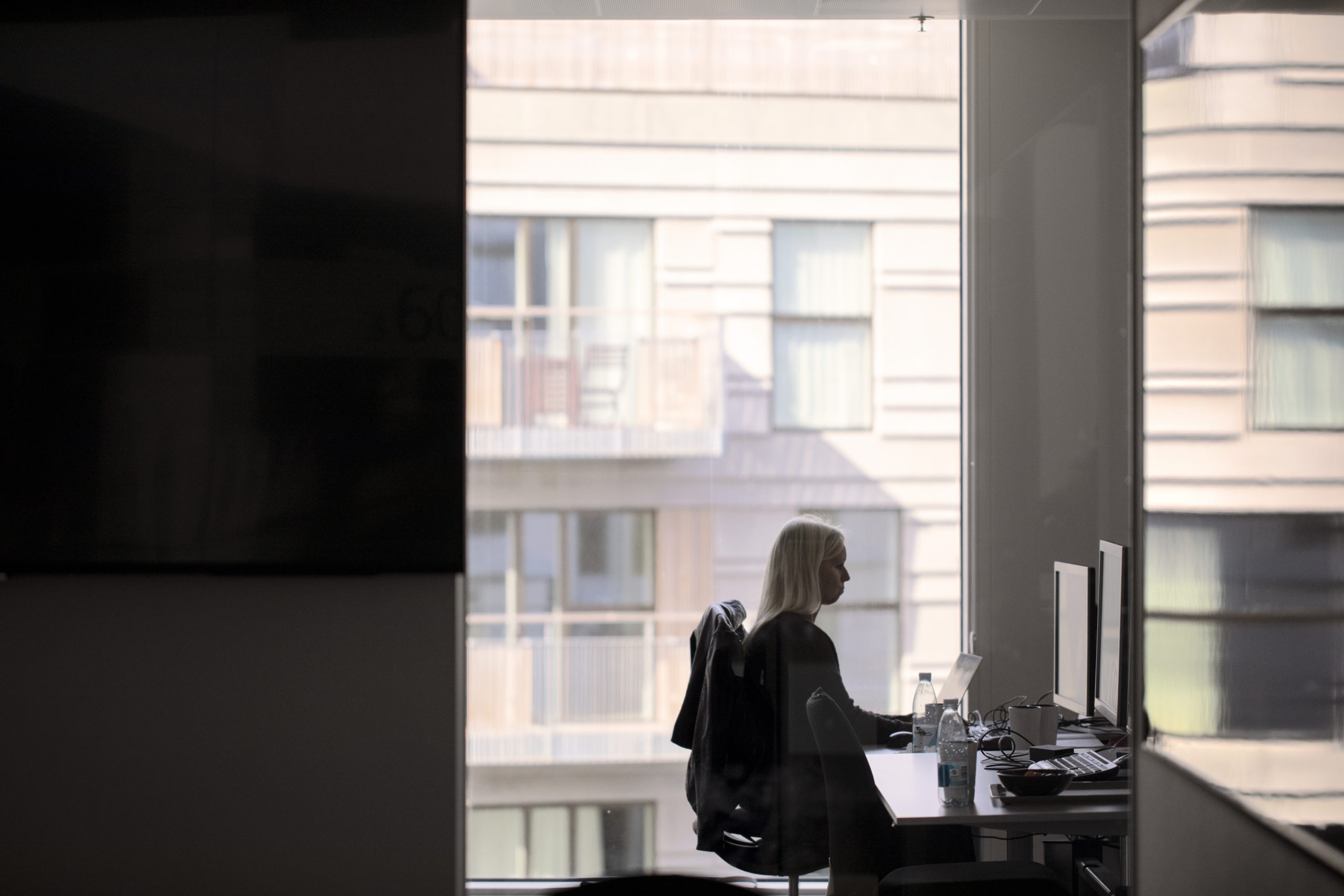 A Microsoft Denmark employee works at an office desk.